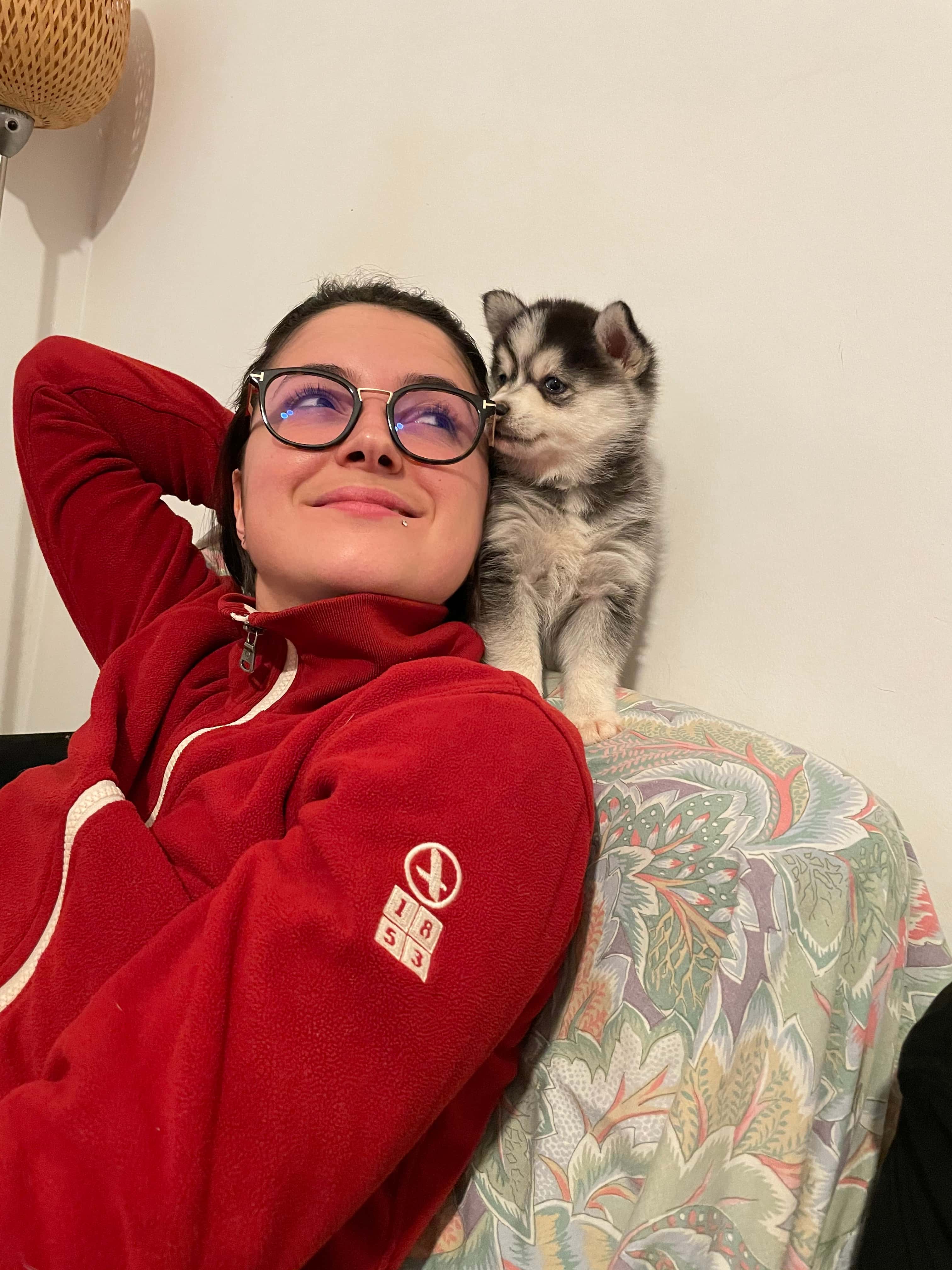 Marine sur le canapé avec un chiot pomsky