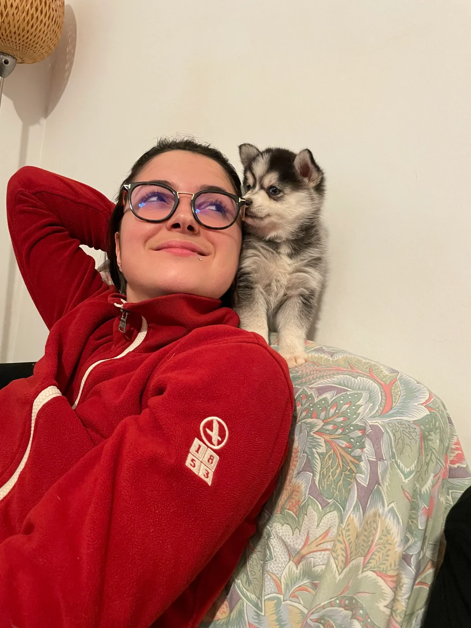 Marine sur un canapé avec un chiot Pomsky